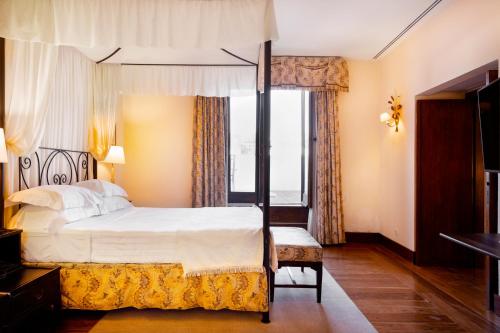 a bedroom with a bed and a large window at Pousada Convento de Vila Viçosa in Vila Viçosa