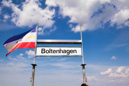 ein Schild mit einer Flagge neben einem Bollinger-Schild in der Unterkunft Residenz Düne III - Ferien-Apartments in Boltenhagen in Boltenhagen