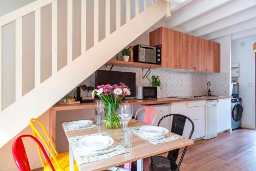 une cuisine et une salle à manger avec une table et des chaises dans l'établissement Casita Do Mar - 3min du Port, à Sarzeau