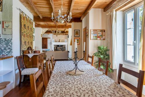 une salle à manger avec une table et des chaises et une cuisine dans l'établissement La Petite Maison d'Allemans - Piscine, Grand Jardin, à Allemans
