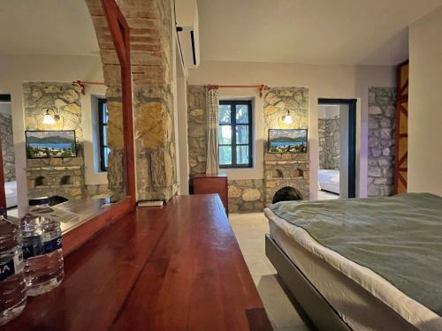 a bedroom with a bed and a stone wall at Symbola Oludeniz Beach Hotel in Oludeniz