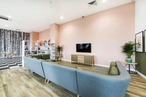 a living room with a couch and a tv at Yugo Catherine House Portsmouth in Portsmouth
