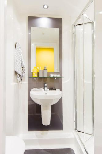a white bathroom with a sink and a shower at Yugo Catherine House Portsmouth in Portsmouth