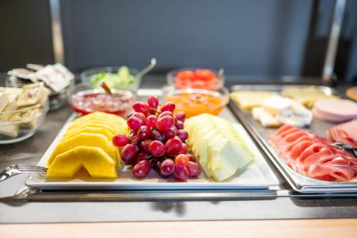 a plate of cheese and fruit on a table at Landgasthof Linde - In ruhiger, ländlicher Umgebung in Deggenhausertal