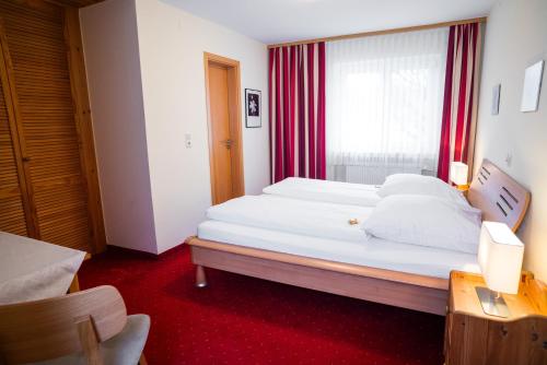 a bedroom with a large white bed and a window at Landgasthof Linde - In ruhiger, ländlicher Umgebung in Deggenhausertal