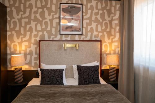 a bedroom with a bed with two lamps on the wall at Grand Halmstad, WorldHotels Crafted in Halmstad