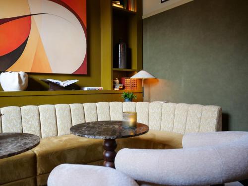 a living room with a couch and a table and chairs at Grand Halmstad, WorldHotels Crafted in Halmstad