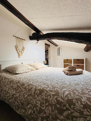 une chambre avec un grand lit avec deux serviettes dessus dans l'établissement Appartement Proche Place Soult l 2 CH l Climatisé, à Castres