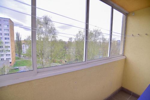 an empty room with two large windows in a building at Apartmány Karviná in Karviná