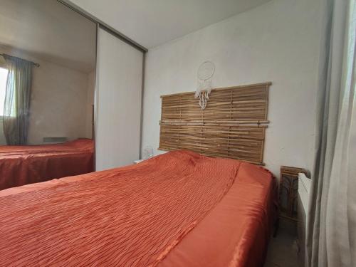 une chambre avec un lit rouge et un miroir dans l'établissement Appartement face à la mer, à Canet
