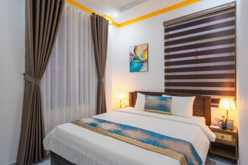 a bedroom with a bed and a large window at ORCHID Hotel in Da Lat