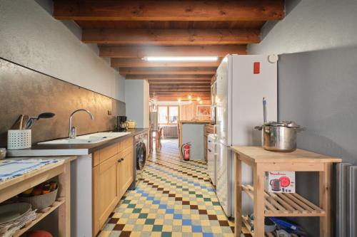 La cuisine est équipée d'un réfrigérateur et d'un sol en damier. dans l'établissement L'auberge du Bati, à Besse