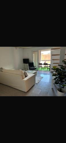 un salon avec un canapé blanc et une table dans l'établissement Duplexmoderne1minutedesplages, à Théoule-sur-Mer