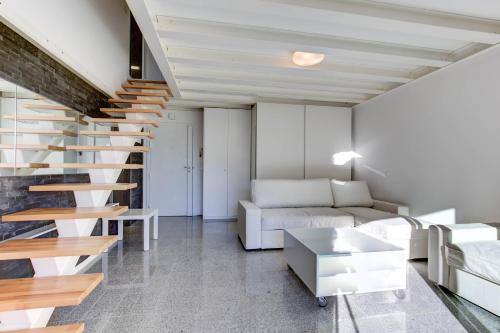 un salon avec un escalier et un canapé dans l'établissement Duplexmoderne1minutedesplages, à Théoule-sur-Mer