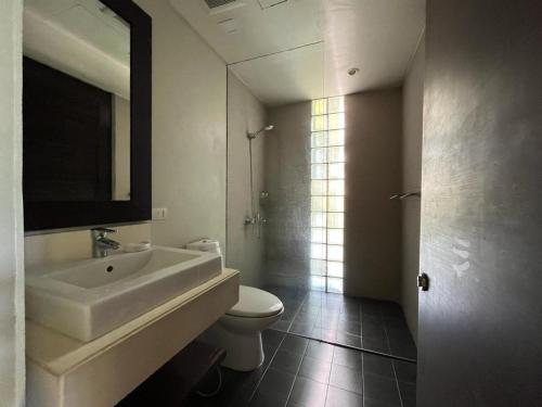 un bagno con lavandino, WC e specchio di Secret Garden at Bangtao Beach a Surin Beach