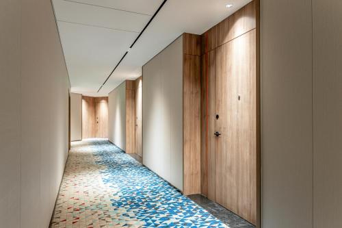 a corridor with a blue and white tile hallway at Holiday Inn Express Shangrao Railway Station by IHG in Shangrao