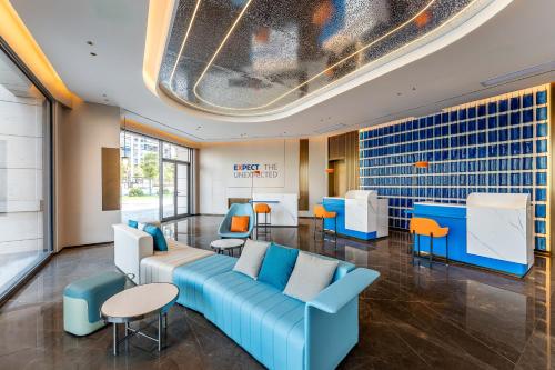 a lobby with a couch and chairs and a table at Holiday Inn Express Shangrao Railway Station by IHG in Shangrao