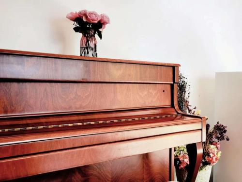 a vase of flowers sitting on top of a piano at 淳安千岛湖乡庐怡陌民宿 in Thousand Island Lake