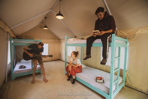 a group of people sitting on bunk beds in a tent at Himalayan Bunker in Hundar