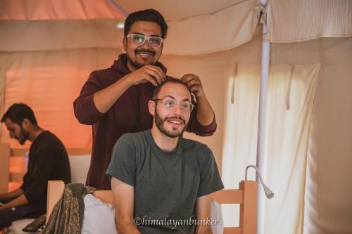 a man getting his hair cut by a barber at Himalayan Bunker in Hundar