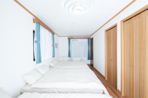 a row of beds in a room with windows at LN27三宮駅15分ペット可1LDK貸切maisonetお宿みやもと in Wada