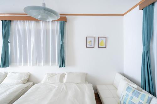 a bedroom with two white beds and a window at LN27三宮駅15分ペット可1LDK貸切maisonetお宿みやもと in Wada