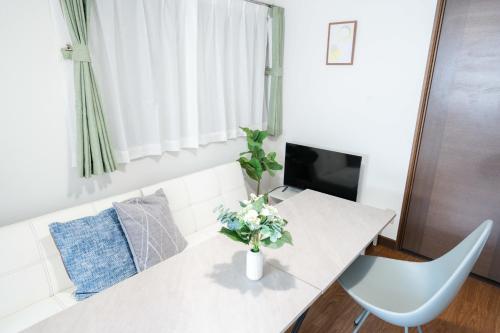 a living room with a table with a vase of flowers at LN27三宮駅15分ペット可1LDK貸切maisonetお宿みやもと in Wada