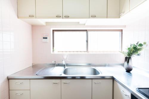 a kitchen with a sink and a window at LN27三宮駅15分ペット可1LDK貸切maisonetお宿みやもと in Wada
