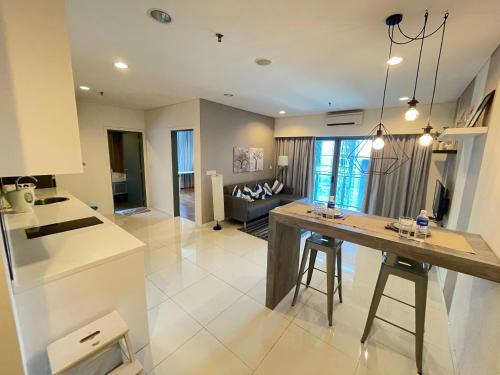 クアラルンプールにあるMercu Summer Suite KLCC by Kuminshuのキッチンとテーブルとソファのあるリビングルーム