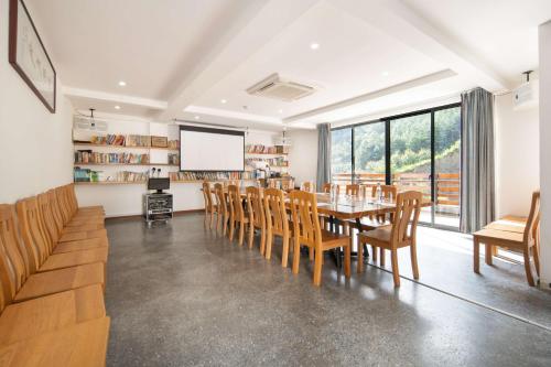 a dining room with a table and chairs and a screen at 淳安千岛湖乡庐怡陌民宿 in Thousand Island Lake