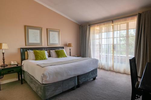 a bedroom with a large bed and a large window at Montclair Resort & Conference in Nyanga