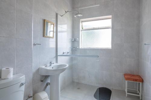 a white bathroom with a sink and a toilet at Montclair Resort & Conference in Nyanga