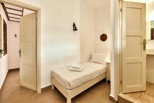 a small room with a small bed and a mirror at Mila Malia Studios Hotel in Malia