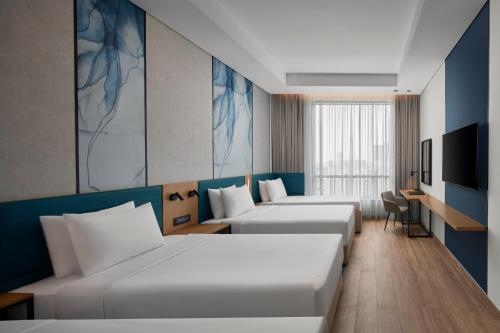 a hotel room with two beds and a television at Courtyard by Marriott Makkah in Makkah
