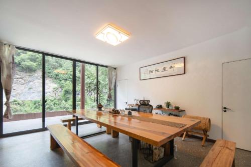 a dining room with a wooden table and benches at 淳安千岛湖乡庐怡陌民宿 in Thousand Island Lake