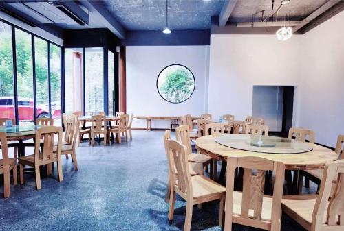 a room with tables and chairs and a large window at 淳安千岛湖乡庐怡陌民宿 in Thousand Island Lake