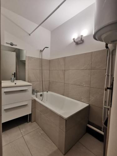 une salle de bain avec une baignoire et un lavabo dans l'établissement Le charme de l'intimité et jeux de rôles, à Sainte-Maxime