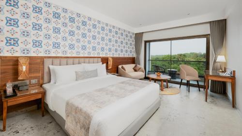 a hotel room with a bed and a large window at Gateway Goa, Palolem in Palolem