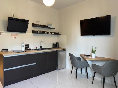 a kitchen with a sink and a table with chairs at Blue View Apartments in Kavala