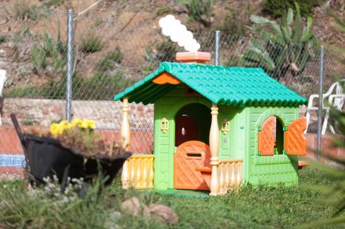 a small toy house with a green roof at MASIA CAN SUNYER AGROTURISMO in La Garriga