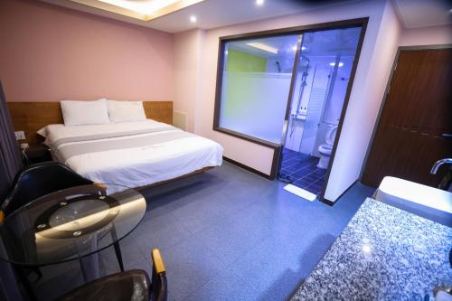 a bedroom with a bed and a glass shower at Seomyeon X in Busan