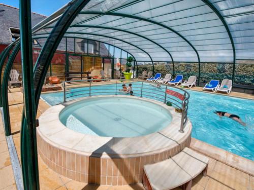 - une piscine avec bain à remous dans un bâtiment dans l'établissement Camping Paradis La Mer d'Iroise - Aquatique Vacances, à Plomodiern