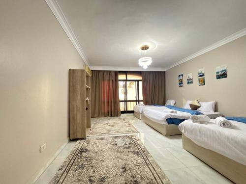 a hotel room with two beds and a couch at Elite Apartments in Mohandseen - Families only in Cairo