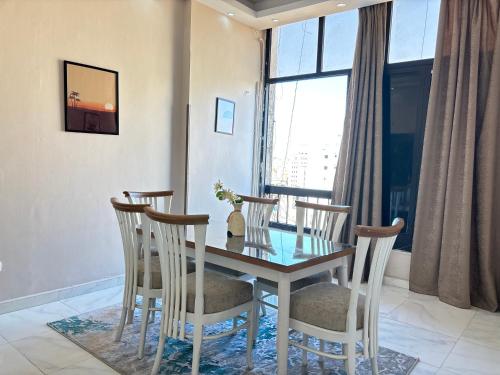 a dining room with a table and chairs and a window at Elite Apartments in Mohandseen - Families only in Cairo