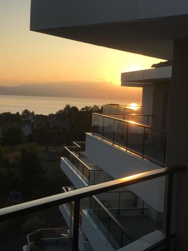 a balcony of a building with the sunset in the background at Splendid 3-room apartment with panoramic view in Neuvecelle