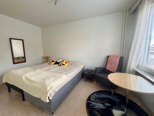 a bedroom with a bed and a table and a chair at Charming Kemi Apartment with Sauna department Free Parking in Kemi