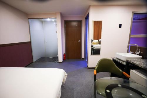 a room with a bed and a bathroom with a sink at Seomyeon X in Busan