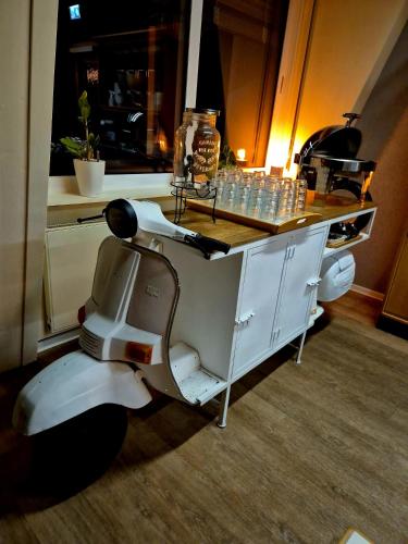 ein Roller neben einem Tresen mit einem Tisch in der Unterkunft Die Heilsbach gGmbH in Fischbach