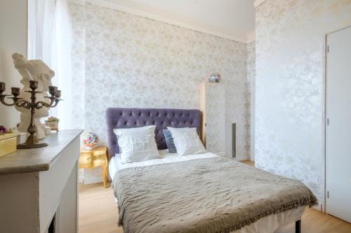 une chambre avec un lit avec une tête de lit bleue dans l'établissement Joli Appartement proche Monaco, à Beausoleil