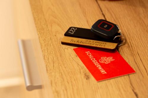 a ticket and a cell phone sitting on top of a table at Hotel & Boarding House Schlosserwirt in Mering